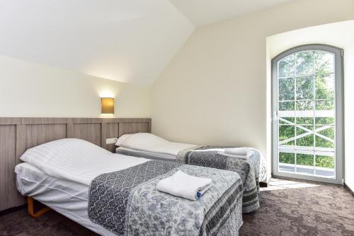 two beds in a room with a window at Auroradream in Motiejiškės