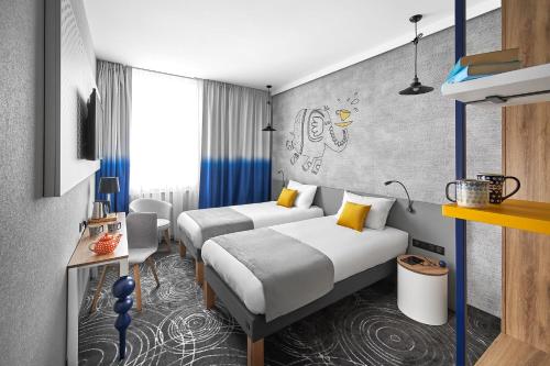 een hotelkamer met 2 bedden en een bureau bij ibis styles Bolesławiec in Bolesławiec