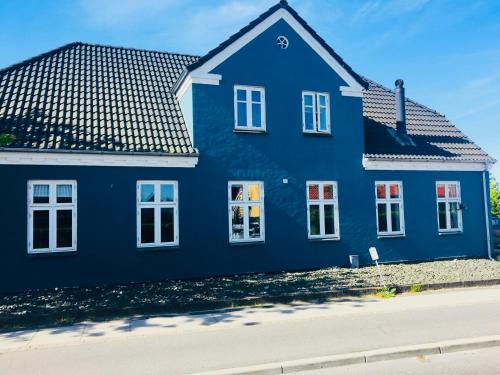 a blue house on the side of a street at Det blågrønne Hus in Hals