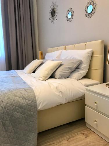 a bedroom with a bed with white sheets and pillows at Apartament Mickiewicza - PKP Station in Przemyśl