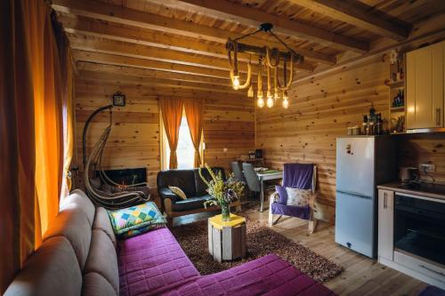 Una sala de estar con un sofá y una cocina. en Meadow Cabin, en Žabljak