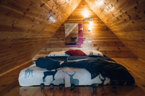 Un dormitorio con una cama en una cabaña de madera. en Meadow Cabin, en Žabljak