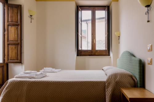 sypialnia z łóżkiem z krzesłem i oknem w obiekcie APPARTAMENTI IN RESIDENCE SENTIERI NELLA ROCCIA w mieście Piaggine