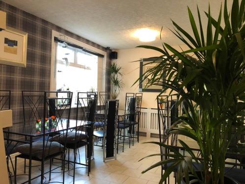 a dining room with a table and chairs and a plant at ParkRoyal Blackpool in Blackpool