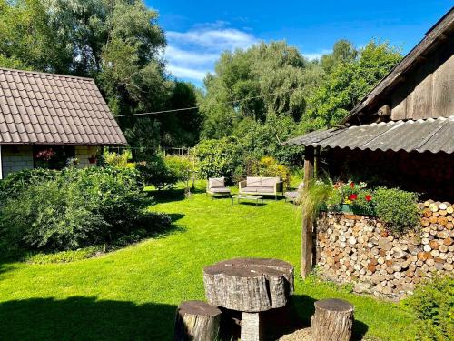 a garden with a bench and a stone building at Bright and cosy place at rustic house in Vecumnieki