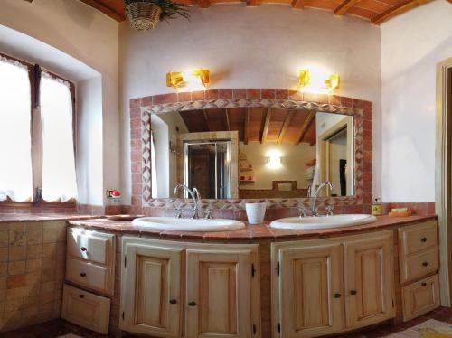 a bathroom with two sinks and a large mirror at Agriturismo Circugnano in Grassina