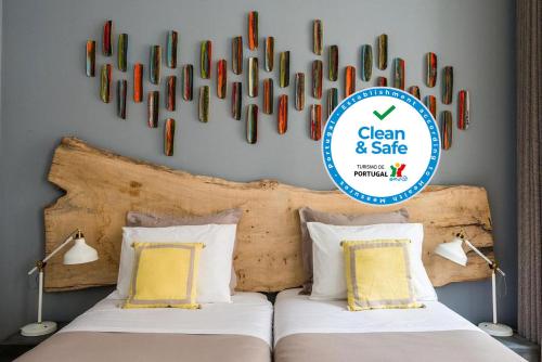 two beds in a bedroom with a sign above them at 19 Tile Ceramic Concept - by Unlock Hotels in Caldas da Rainha