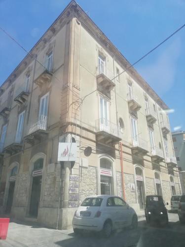 a building with a car parked in front of it at Sapore di Sale - Sicily Rooms in Siracusa