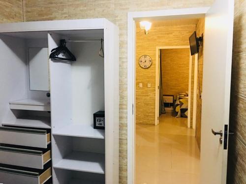 um corredor com um quarto com um relógio na parede em Hotel das Palmas em Florianópolis