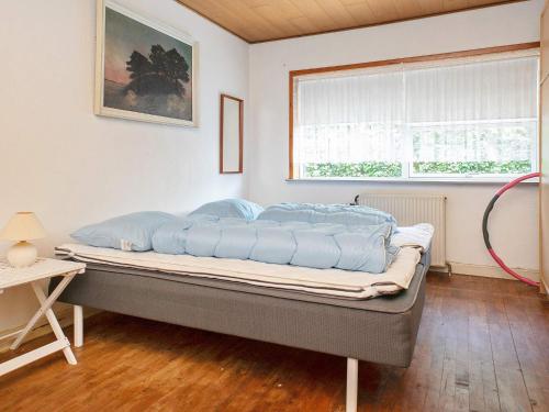 a bed sitting in a room with a window at Holiday home Varde II in Varde