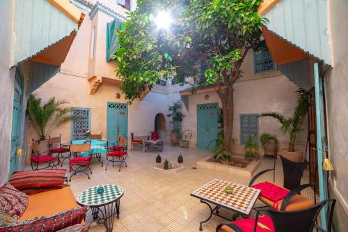 un patio con mesas y sillas en Riad Dar Marhaba en Marrakech