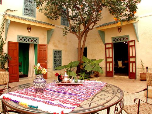 une table avec un tissu de table rayé sur une terrasse dans l'établissement Riad Dar Marhaba, à Marrakech