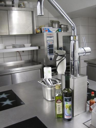 a kitchen counter with a mixer and a bottle of alcohol at Hotel Lekker in Neumagen-Dhron