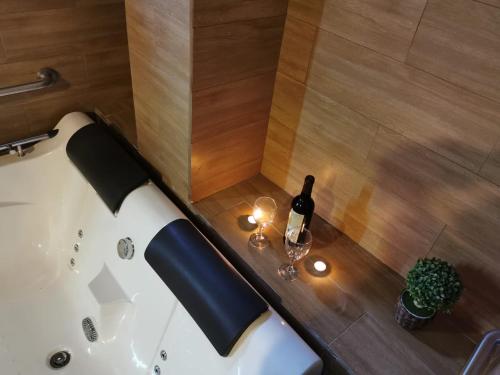 a bath tub with a bottle of wine and a glass at Hotel Dia y Noche in Lima