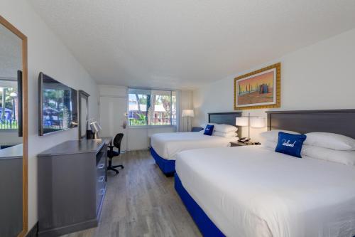 a hotel room with two beds and a desk at The Island Resort at Fort Walton Beach in Fort Walton Beach