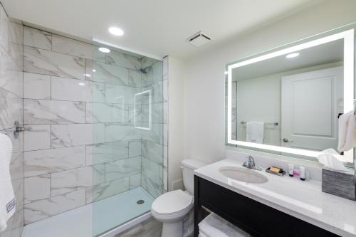a bathroom with a sink and a toilet and a mirror at The Island Resort at Fort Walton Beach in Fort Walton Beach