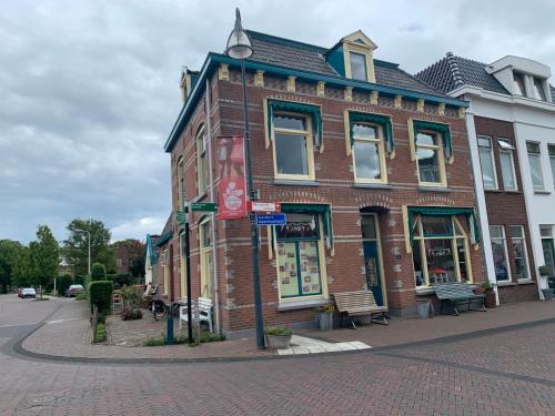 a brick building on the corner of a street at Retro-huisje GoedFout in Olst