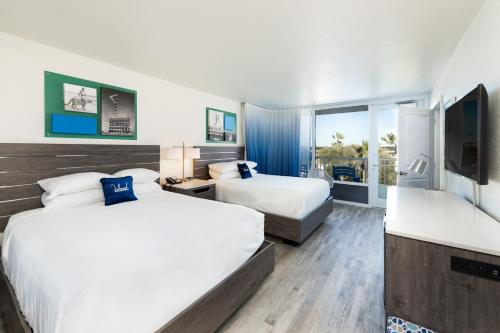 a hotel room with two beds and a television at The Island Resort at Fort Walton Beach in Fort Walton Beach