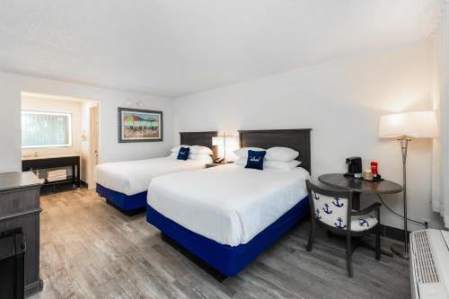 a hotel room with two beds and a desk at The Island Resort at Fort Walton Beach in Fort Walton Beach