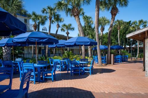 a group of blue tables and chairs with umbrellas at The Island Resort at Fort Walton Beach in Fort Walton Beach