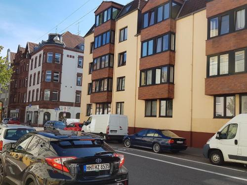 eine Gruppe von Autos, die auf einer Straße mit Gebäuden geparkt sind in der Unterkunft Nauwieser Apartments in Saarbrücken