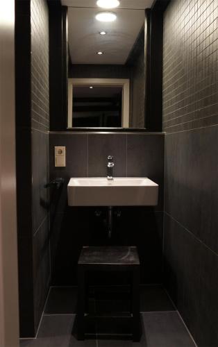 a bathroom with a sink and a mirror at Aparthotel MyCologne in Cologne