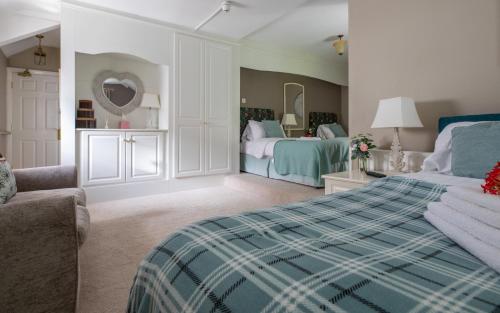 a bedroom with two beds and a couch at Plas Maenan in Conwy