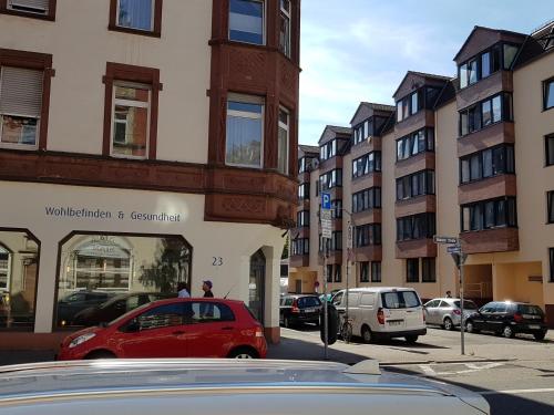 薩爾布呂肯的住宿－瑙維瑟公寓式酒店，一辆红色的汽车停在城市街道上,街道上有许多建筑