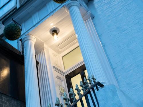 a house with two columns and a porch with potted plants at MyUKSuites in Hull