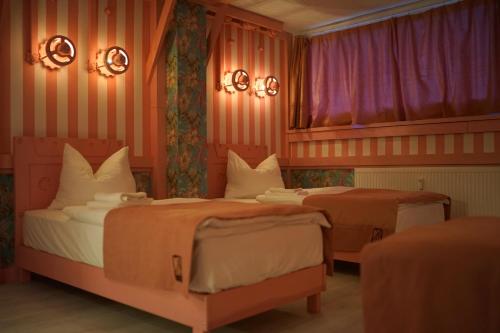 two beds in a room with pink walls at Aparthotel MyCologne in Cologne