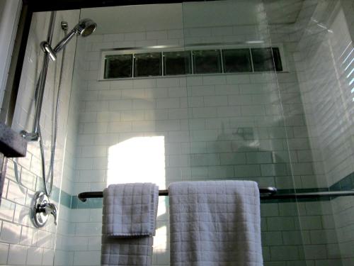y baño con ducha y 2 toallas. en Merrickville Guest Suites en Merrickville