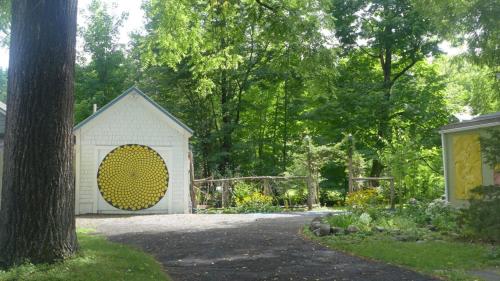 a white shed with a large yellow door in a yard at Morning Glory B&B in Woodstock