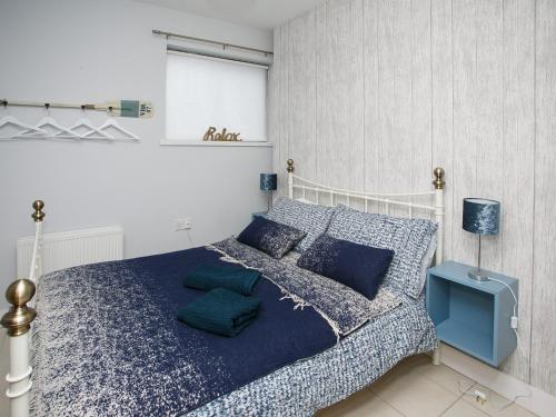 ポートラッシュにあるThe Nautical Apartmentのベッドルーム1室(青い掛け布団、枕付)