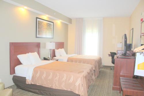 a hotel room with two beds and a flat screen tv at Quality Inn Lake City in Lake City