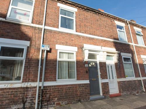 a red brick building with a black door and white windows at Townhouse @ Newlands Street Stoke in Etruria