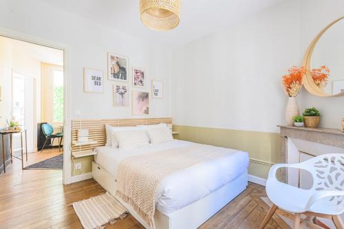 ein weißes Schlafzimmer mit einem Bett und einem Spiegel in der Unterkunft MM Suites Reims Centre Terasse in Reims