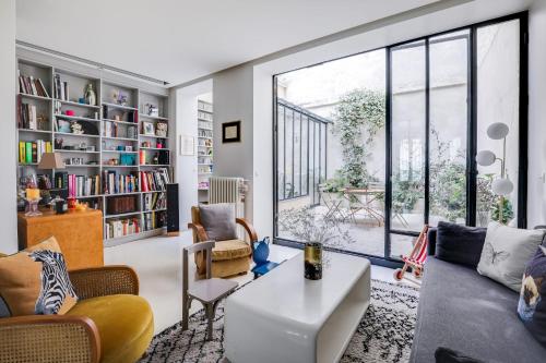 een woonkamer met meubilair en een groot raam bij Sumptuous house with patio in Parijs