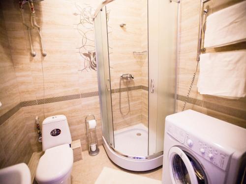 a bathroom with a shower and a washing machine at Apartments Etazh in Odesa