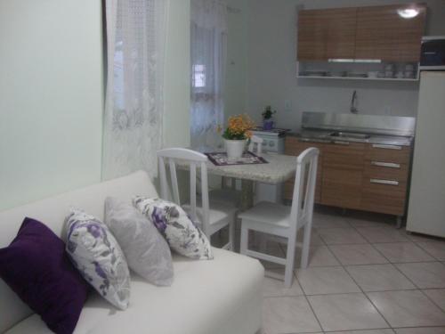 sala de estar con sofá blanco y mesa en Studio 80m da Praia, en Bombinhas
