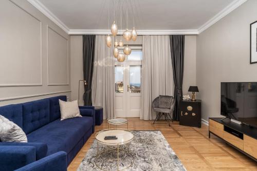 uma sala de estar com um sofá azul e uma televisão em Luxury Peitho Residence em Opatija