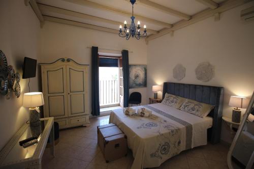 a bedroom with a large bed and a chandelier at Noto da Quassu' Bed and Breakfast in Noto