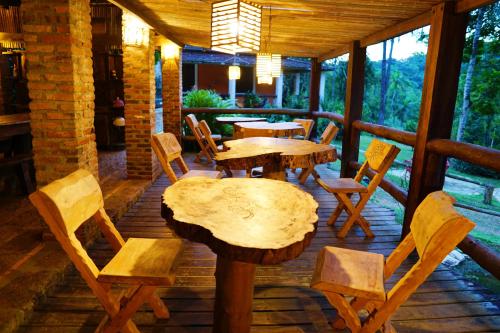 a wooden table and chairs on a porch at Pousada Arapassu in Eldorado