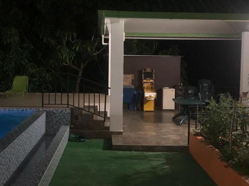 an outdoor patio at night with a table and a pool at CASA EL MIRADOR in Anapoima