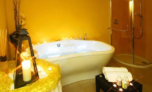 a bathroom with a bath tub and a sink at Apparthotel Gartenresidence Nalserhof in Nalles