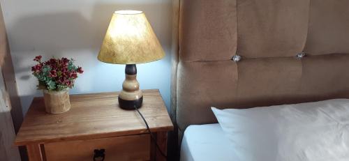 a lamp on a night stand next to a bed at Estúdio conceito aberto - 3 pessoas in Araranguá