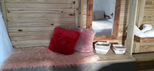 a room with a red pillow and a mirror at Estúdio conceito aberto - 3 pessoas in Araranguá