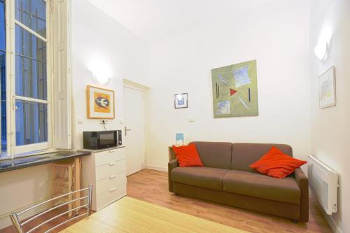 un salon avec un canapé et une horloge au mur dans l'établissement Quiet Studio In The Center Of Lyon, à Lyon