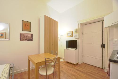 Cette petite chambre comprend une table et une télévision. dans l'établissement Quiet Studio In The Center Of Lyon, à Lyon