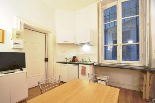 une cuisine avec une table et des chaises et une fenêtre dans l'établissement Quiet Studio In The Center Of Lyon, à Lyon