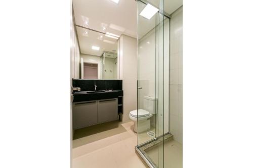 a bathroom with a toilet and a glass shower at WI-FI 350MB | Foodhall | 450m do Shopping #CA14 in Florianópolis